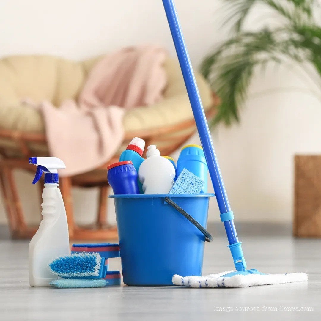 Cleaning supplies including a blue bucket filled with various cleaning products, a mop, and sponges in a tidy indoor setting, emphasizing professional cleaning services.