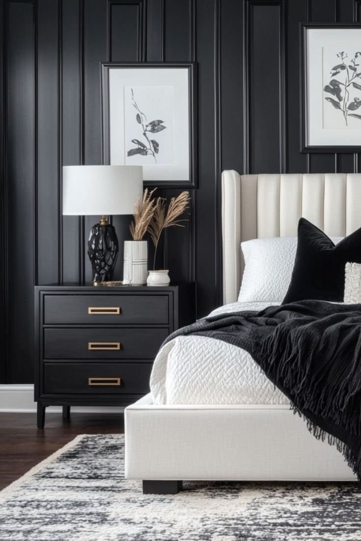 Modern bedroom interior featuring a white upholstered bed with black throw blanket, stylish nightstand with lamp and decorative accents, against a dark paneled wall, emphasizing a clean and inviting atmosphere for deep cleaning services.